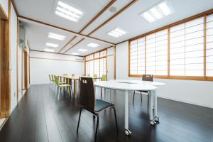 a row of tables and chairs in a room with windows at みずほガーデンロッジ in Kyotamba