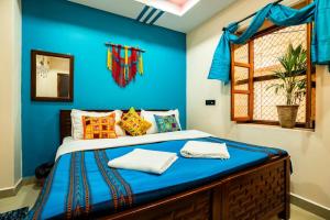 a bed in a room with a blue wall at Heart and Soul of Jaisalmer in Jaisalmer