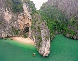 an aerial view of a beach with a large rock formation at Cat Ba island Budget Pool Stay in Cat Ba