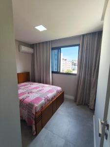a bedroom with a bed and a large window at Apartmento em Castelhanos-Es in Anchieta