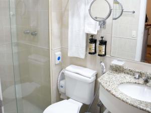 a bathroom with a toilet and a sink and a shower at Mercure Sao Caetano do Sul in São Caetano do Sul