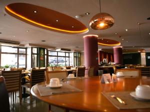 a restaurant with a wooden table and chairs and tables and windows at Mercure Sao Caetano do Sul in São Caetano do Sul +28 photos