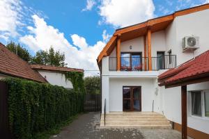 a white house with a balcony and stairs at Mures Stay in Târgu-Mureş