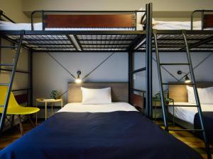a bedroom with two bunk beds with a blue bed at Minn Juso in Osaka