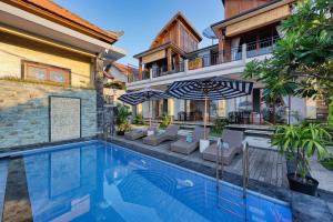 ein Außenpool mit Stühlen und Sonnenschirmen neben einem Haus in der Unterkunft Sinta Nusa Villa in Nusa Penida + 25 Fotos