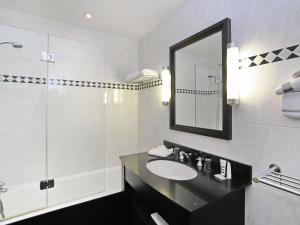 un bagno bianco con lavandino e doccia di Hotel Mercure La Baule Majestic a La Baule Altre 17 foto