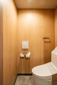 a bathroom with a white toilet and wooden walls at Pyramiden view inn in Banī Ghālib +126 photos