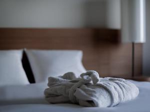 a towel sitting on top of a bed at Pullman Basel Europe in Basel