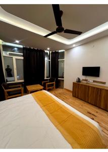 a bedroom with a bed and a flat screen tv at Varlaxmi Vatika in Rānīkhet +21 photos