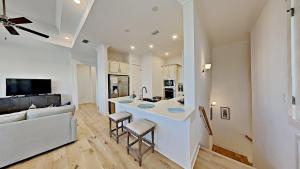 a kitchen and living room with a bar and a couch at Settle By The Sea in Inlet Beach