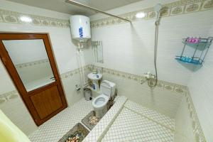a small bathroom with a toilet and a door at Shokhname in Khiva +23 photos