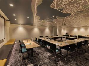 a conference room with tables and chairs and a map on the wall at Ibis Christchurch in Christchurch