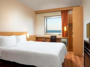 a hotel room with a bed and a desk and a window at Ibis Istanbul Zeytinburnu in Istanbul