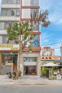 un edificio con un albero di fronte di Bao Chau Hotel a Da Nang