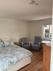 a bedroom with two chairs and a bed and a table at Studio granny flat in Sydney
