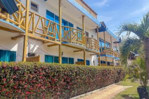 a building with balconies and a hedge in front of it at La Rivera Playa Palomino in Palomino