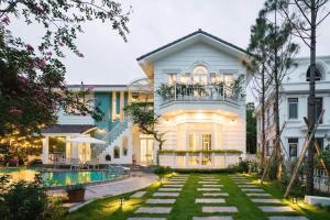 ein Haus mit einem Swimmingpool davor in der Unterkunft Villa B82 Flamingo Đại Lải Resort in Phúc Yên