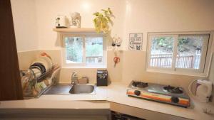 BootinにあるCABIN C at Bigang Munti Beach Resortのキッチン(シンク、コンロ付)、窓2つが備わります。 +15枚の写真