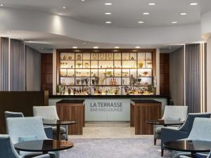 una zona de estar con mesas y sillas en el vestíbulo en Sofitel London Gatwick, en Horley