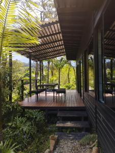 a porch of a house with a table and benches at Refugio Madremonte in Medellín