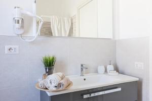 a bathroom with a sink and a mirror at Villa dei Fiori Apartments in Cervia