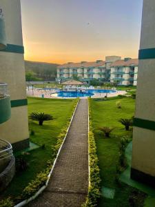 a walkway through a park with buildings in the background at Apartamento Aldeia das Águas l Condomínio Village das Águas in Barra do Piraí