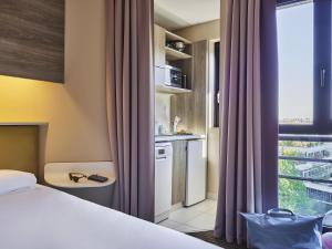 a hotel room with a bed and a window at AppartHotel Mercure Paris Boulogne in Boulogne-Billancourt