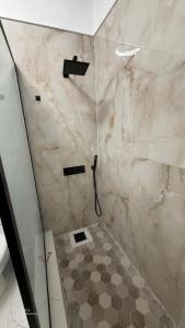 a bathroom with a shower with a tiled floor at The cozy spot negril in Negril