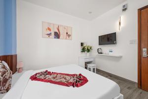 una camera da letto bianca con un letto e una TV di Bao Chau Hotel a Da Nang Altre 8 foto