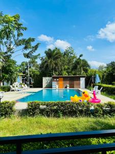 a swimming pool with a toy in the grass at Monmai Resort Huahin in Hua Hin