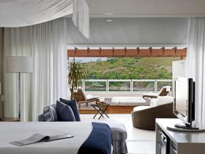 a hotel room with a bed and a living room at Hotel Jequitimar Guaruja Resort & Spa by Accor - Ex Sofitel in Guarujá