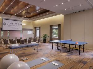 a conference room with two ping pong tables and a screen at Pullman Sydney Olympic Park in Sydney