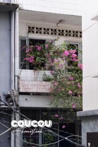 a window box filled with pink flowers on a building at Coucou Homestead I - Homestay & Dorm District 1 in Ho Chi Minh City