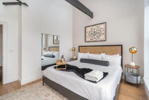 a bedroom with a large bed with white sheets at The Saddlery - Mic Drop - Walk to Broadway in Nashville