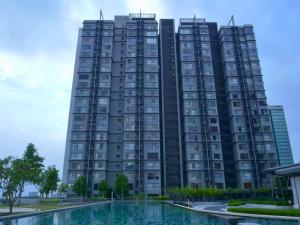 ein hohes schwarzes Gebäude mit einem Pool davor in der Unterkunft Chic & Cozy Studio - HYVE SOHO Cyberjaya in Cyberjaya