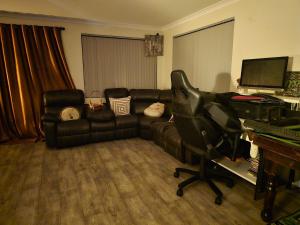 a living room with a couch and a piano at Aragon Demi-Apartment Baldivis in Baldivis