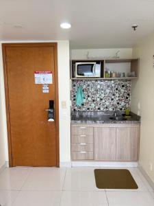 a room with a kitchen with a door and a microwave at Hotel tropical Manaus suite luxo in Manaus