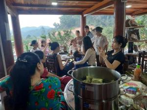 een groep mensen die rond een tafel in een kamer zitten bij Solaria Garden Sóc Sơn in Sóc Sơn