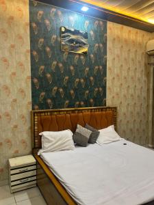 um quarto com uma cama grande e uma parede com flores em Hari Dham em Vrindāvan