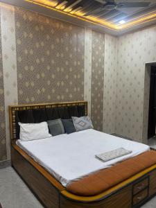 um quarto com uma cama grande com lençóis brancos em Hari Dham em Vrindāvan mais 8 fotografias