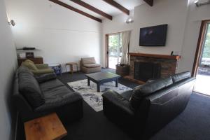 Una sala de estar con un sofá y una chimenea. en 30 Harrogate Street, en Hanmer Springs