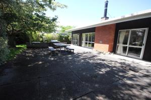 un patio con 2 bancos frente a un edificio en 30 Harrogate Street, en Hanmer Springs