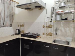 a small kitchen with a sink and a stove at ALPANEST - Near GMCH and B Barooah Cancer in Guwahati +24 photos