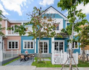 a blue house with a table in front of it at Zenda Villa Novaworld Phan Thiết in Bình Tú