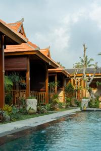 a house with a swimming pool in front of it at Duara Wooden Suite in Ubud