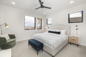 una camera da letto bianca con un letto e una sedia di Silly Goose Lodge a Granby