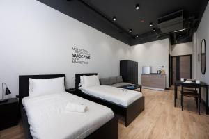 a bedroom with two beds and a desk and a couch at Cozy Retreat studio by Spacey in Duqm 86 in Duqm