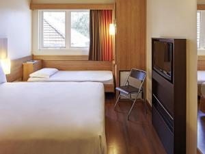 a hotel room with two beds and a television at ibis Porto Alegre Moinhos de Vento in Porto Alegre +108 photos