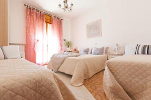a bedroom with two beds and a window at Villa dei Fiori Apartments in Cervia