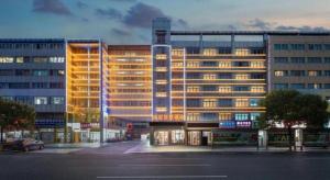 a large building with lights on in a city at Yiwu Guomao Hotel in Yiwu
